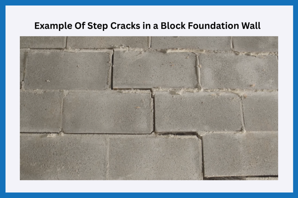 An image of step cracks that have formed in a concrete block foundation wall.